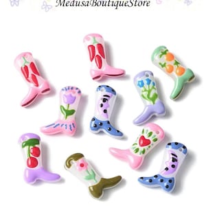 May include: A collection of colorful, miniature cowboy boots. Each boot features a unique design, including chili peppers, flowers, and polka dots. The boots are in shades of pink, blue, green, and purple, with white accents. The text "Medusa Boutique Store" is at the top.