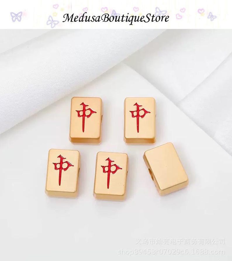 Puede incluir: Fichas de Mahjong doradas con caracteres chinos rojos. Las fichas rectangulares tienen bordes redondeados. La imagen incluye el texto "Medusa Boutique Store".