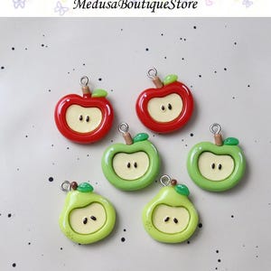 Pode incluir: Seis pingentes em forma de fruta: duas maçãs vermelhas, duas maçãs verdes e duas peras verdes. Cada pingente tem um centro amarelo claro com dois pequenos pontos, um caule marrom e uma folha verde. Ideal para fazer joias.