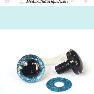 May include: A pair of black safety eyes with a blue glitter trim, a washer, and a plastic back for attaching the eyes to a stuffed animal or craft project.