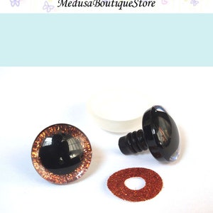 May include: A pair of brown and black safety eyes with a glitter rim, a black plastic washer, and a white plastic washer. The safety eyes are used for making stuffed animals.