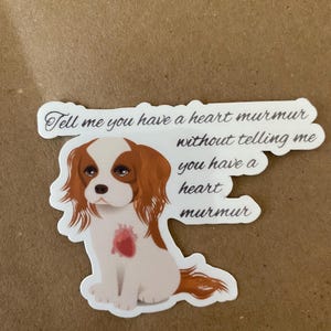 May include: A sticker featuring a cartoon Cavalier King Charles Spaniel with a red heart on its chest. The text reads "Tell me you have a heart murmur, without telling me you have a heart murmur."