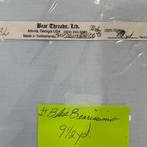 May include: A white ceramic mug with a black handle and the text "But First, Coffee" in a black, bold font. The mug is sitting on a wooden surface. The mug is approximately 4 inches tall.