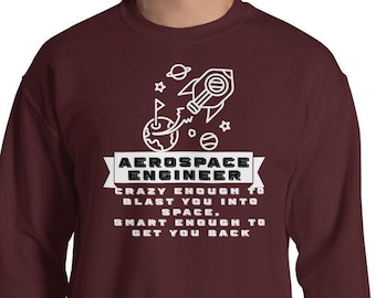 May include: A maroon sweatshirt with a white graphic of a rocket ship and the text "AEROSPACE ENGINEER CRAZY ENOUGH TO BLAST YOU INTO SPACE, SMART ENOUGH TO GET YOU BACK".