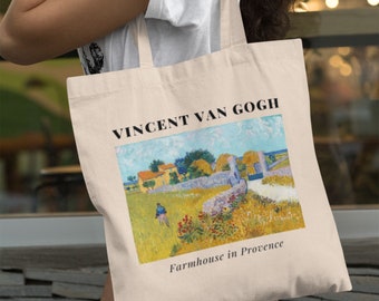 May include: A white canvas tote bag with a painting of a farmhouse in Provence by Vincent van Gogh. The text "Vincent van Gogh" and "Farmhouse in Provence" is printed on the bag.