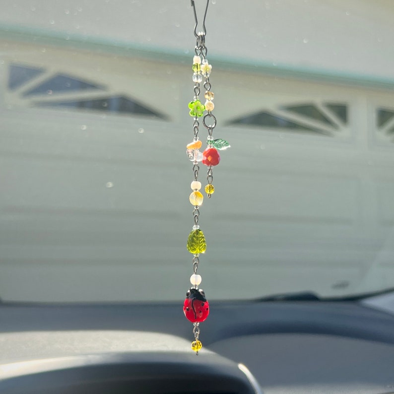 LadyBug and orange tangerine fruit charm. includes floral beads, dyed orange and clear quartz to bring in that good energy, a leaf bead to bring in that garden feel, a lovely little whimsical charm