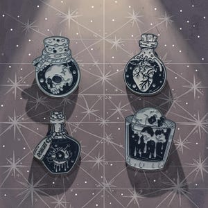 Könnte beinhalten: Set aus drei Keramikbechern mit gesprenkelter, matter Oberfläche. Die Becher sind in Creme-, Hellgrau- und Dunkelgrautönen gehalten. Jede Tasse hat ein schlichtes, minimalistisches Design.