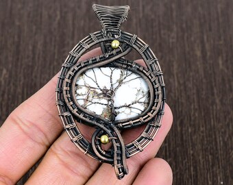 May include: A copper wire wrapped pendant featuring a white and brown tree agate stone. The pendant has a copper wire bail and two gold beads.