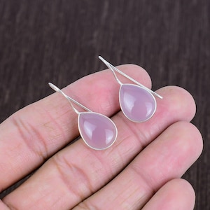 Peut inclure: Une paire de boucles d'oreilles pendantes en argent avec des pierres roses en forme de goutte.