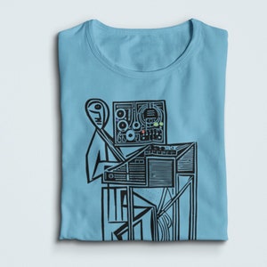 Puede incluir: Una camiseta azul claro con una ilustración negra de una persona tocando un sintetizador.