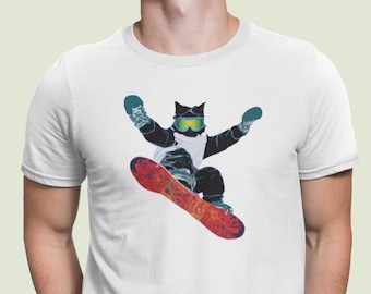 Könnte beinhalten: Weißes T-Shirt mit einem Aufdruck eines schwarzen Katers, der eine Skimaske und eine Skibrille trägt und einen Berg hinunter snowboarden.
