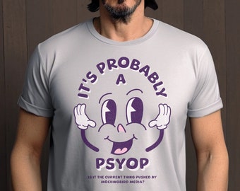 May include: A gray t-shirt with a cartoon face and the text "It's probably a psyop. Is it the current thing pushed by mockingbird media?"