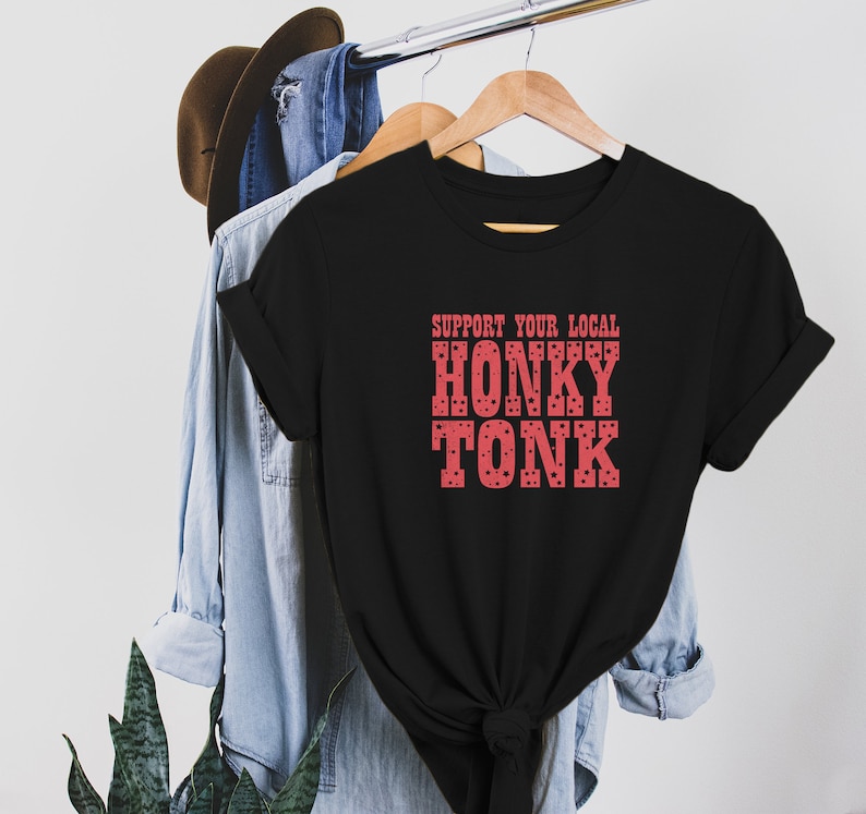 May include: Black t-shirt with a red graphic that says "Support Your Local Honky Tonk". The graphic has a polka dot pattern.