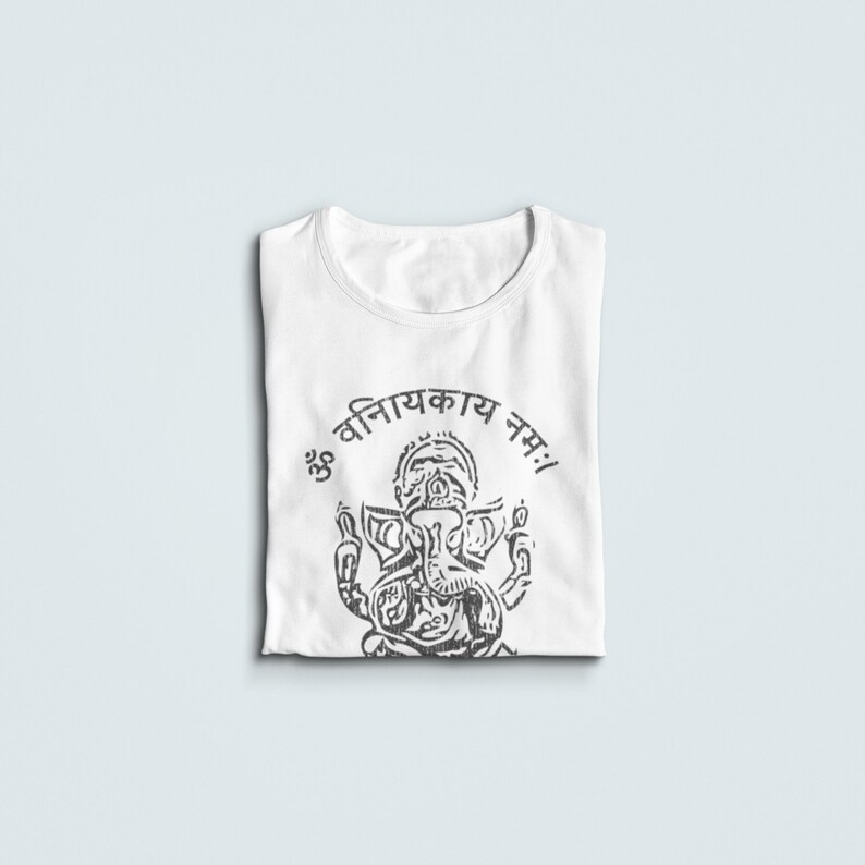 May include: White t-shirt with a black and white illustration of the Hindu deity Ganesha. The text "ॐ विनायकाय नमः!" is printed above the image.