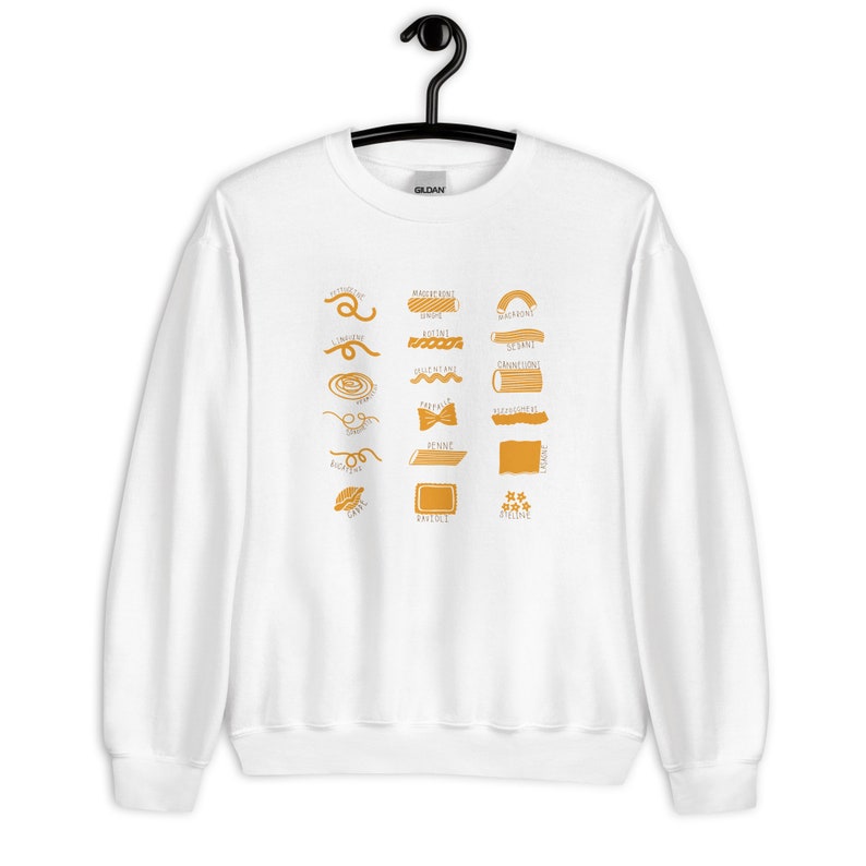 Peut inclure: Sweat-shirt blanc avec un graphique de diff&eacute;rents types de p&acirc;tes, chacun &eacute;tiquet&eacute; avec son nom en texte jaune. Les formes de p&acirc;tes comprennent : Maccheroni, Maccheroni Grande, Bucatini, Spaghetti, Rigatoni, Cannelloni, Orecchiette, Farfalle, Riffiolini, Fiocchi, Penne, Lasagne, Cappe, Ravioli, Stelline.