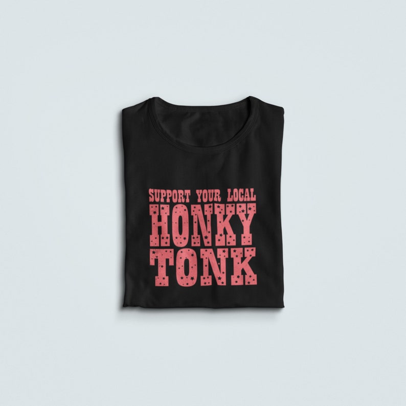 May include: Black t-shirt with the text "Support Your Local Honky Tonk" in pink with a polka dot pattern.