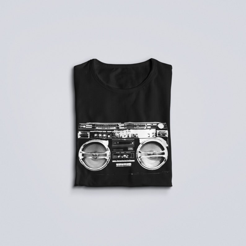 May include: Black t-shirt with a white graphic of a vintage boombox.