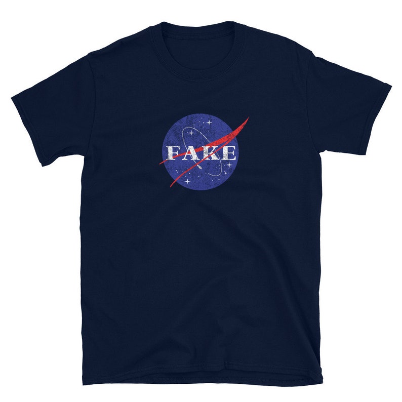 K&ouml;nnte beinhalten: Ein marineblaues T-Shirt mit einem Vintage-NASA-Logo mit dem Wort "FAKE" in wei&szlig;.
