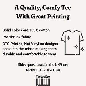 May include: A black and white illustration of a t-shirt with the text "A Quality, Comfy Tee With Great Printing". The text below the illustration says "Solid colors are 100% cotton, Pre-shrunk fabric, DTG Printed, Not Vinyl so designs soak into the fabric making them durable and comfortable to wear. Shirts purchased in the USA are PRINTED in the USA. TheLowKey".