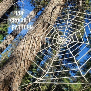 May include: A large, off-white crocheted spider web with a radial design, featuring concentric hexagonal rings connected by radiating spokes. The text "PDF CROCHET PATTERN" is printed in white on the left side of the image.