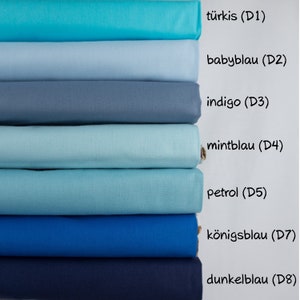 Könnte beinhalten: Ein Stapel von acht Stoffmustern in Blautönen, von Türkis bis Dunkelblau. Die Muster sind mit ihren deutschen Farbnamen beschriftet: türkis (D1), babyblau (D2), indigo (D3), mintblau (D4), petrol (D5), königsblau (D7) und dunkelblau (D8).