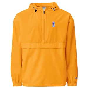 Könnte beinhalten: Senfgelbe Anorakjacke mit halbem Reißverschluss und Kapuze. Die Jacke hat ein kleines, farbenfrohes rechteckiges Design auf der Brust und ein Champion-Logo auf dem Ärmel. Der Anorak hat eine Vordertasche und verstellbare Kordelzüge.