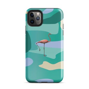 Puede incluir: Funda de teléfono con un diseño de flamenco rosa sobre un fondo abstracto turquesa, azul y beige. La funda tiene un acabado brillante y un borde negro. El flamenco está representado sobre una pata.