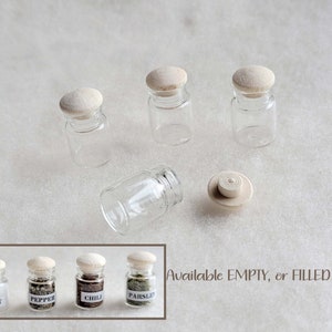 May include: Set of five small glass jars with wooden lids. The jars are available empty or filled with spices, such as salt, pepper, chilli, and parsley. Available EMPTY, or FILLED
