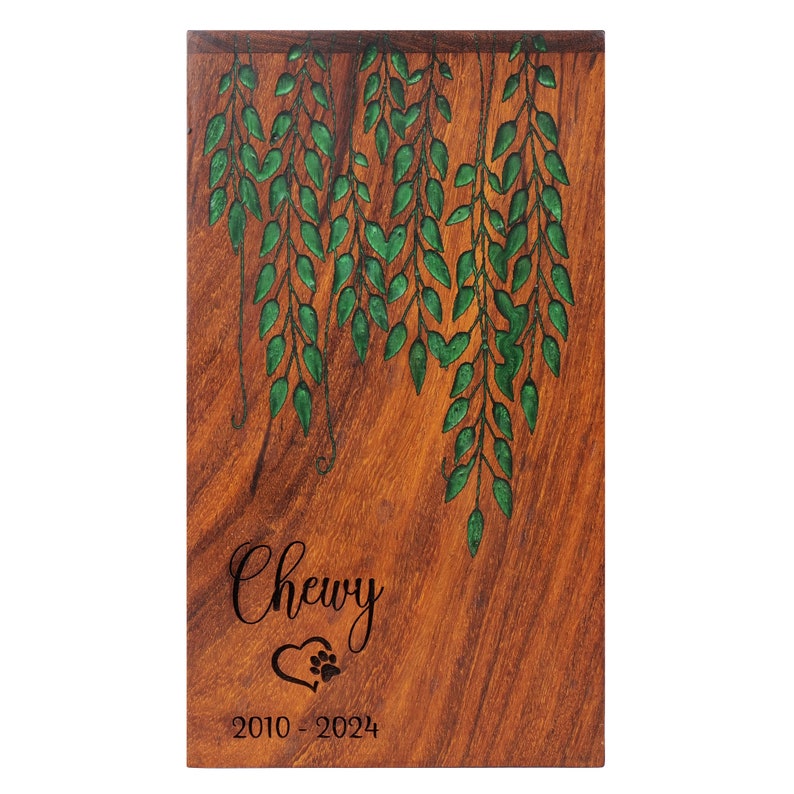 May include: Wooden pet memorial plaque with a green leafy design and the inscription "Chewy 2010 - 2024" with a paw print heart.