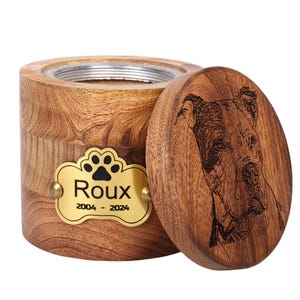 May include: Wooden pet urn with a gold plaque that reads "Roux 2004 - 2024" and a paw print. The lid of the urn has a laser engraved image of a dog.