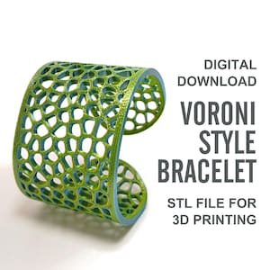 Può includere: Un bracciale Voroni stampato in 3D nei toni del verde e del blu. Il design traforato presenta un motivo a nido d'ape. L'immagine include il testo "DOWNLOAD DIGITALE", "BRACCIALE STILE VORONI" e "FILE STL PER LA STAMPA 3D".