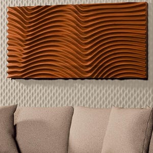 May include: A rectangular wall art piece featuring a deep copper-colored finish with a series of horizontal, undulating wave patterns. The artwork is mounted on a textured, light beige wall paneling surface above a neutral-toned sofa.