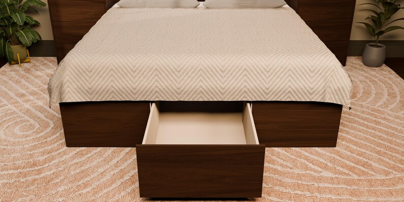 May include: A dark brown wooden bed frame featuring a large, open storage drawer at the base. The bed is covered with a light-coloured, chevron-patterned quilt. The frame includes integrated side panels that extend to form matching bedside tables.