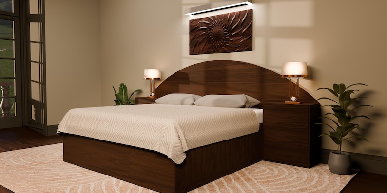 May include: A dark wood bed frame featuring a large, arched headboard with integrated side tables and two lamps. The bed is dressed in a light-coloured, textured quilt with two matching pillows. Above the headboard hangs a dark, circular wall art piece.