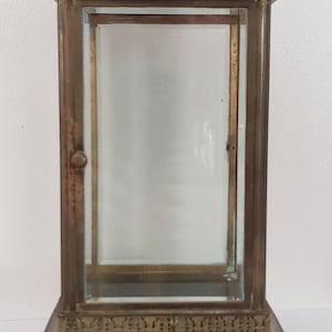 K&ouml;nnte beinhalten: Eine Vitrine aus Messing mit einer Glasfront und einer Glast&uuml;r. Die Vitrine hat ein dekoratives Design an der Ober- und Unterseite.