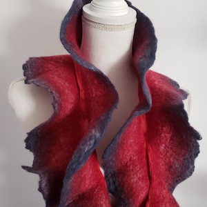 May include: A red and blue ombre ruffled scarf made of felted wool.