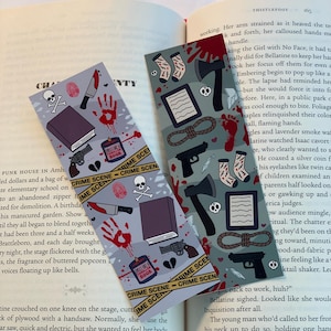 May include: Two crime-themed bookmarks with illustrations of a book, gun, knife, handprint, and crime scene tape. One bookmark has a skull and crossbones. The background is a book.