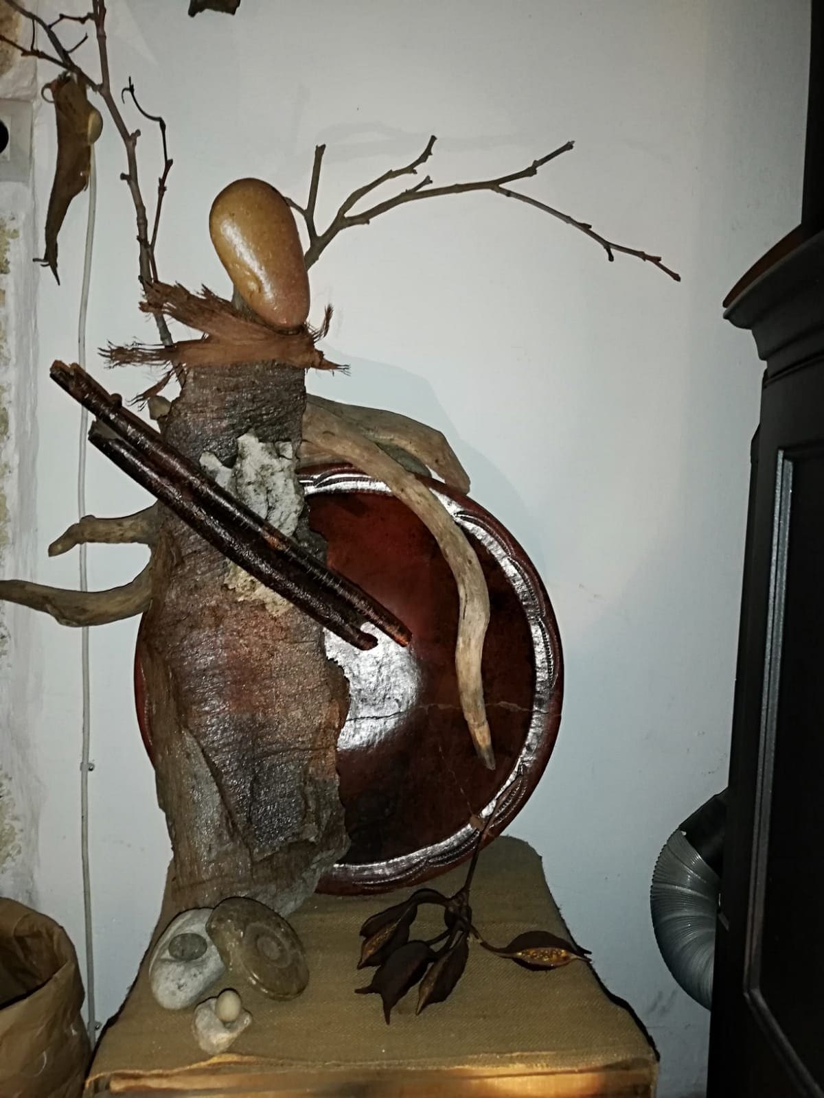 Sculpture Murale en Galets et Écorces d'un Pèlerin Dans Le Vent