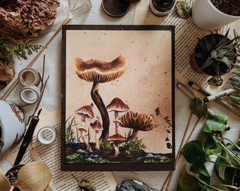Könnte beinhalten: Ein Aquarellgemälde mit mehreren Pilzen in Braun- und Beigetönen, vor einem hellbraunen Hintergrund. Das Kunstwerk ist von einem dunkelbraunen Rahmen umgeben und zeigt eine Vielzahl von Pilzformen und -größen mit grünem Moos an der Basis.
