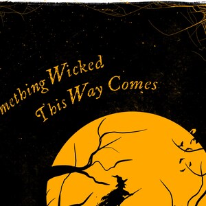 May include: A black graphic print featuring a large orange full moon, a silhouette of a witch flying on a broomstick, and bare tree branches. The text "Something Wicked This Way Comes" is printed in orange, with orange spiderwebs in the corners.