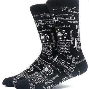 Könnte beinhalten: Ein Paar schwarze Socken mit weißem wissenschaftlichem Design. Die Socken zeigen Gleichungen, Diagramme und die Wörter "Energie", "Aktivität" und "Atomwellen". Die Socken sind aus weichem Material und für den Alltag geeignet.