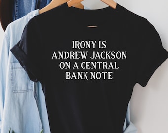 May include: Black t-shirt with white text that reads "IRONY IS ANDREW JACKSON ON A CENTRAL BANK NOTE"