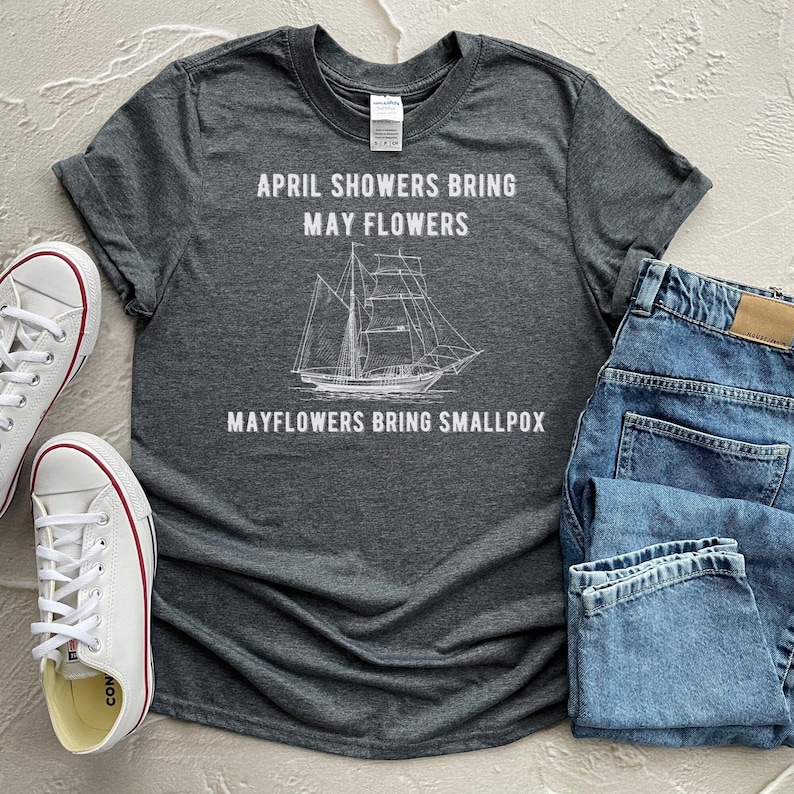 K&ouml;nnte beinhalten: Ein dunkelgraues T-Shirt mit einem wei&szlig;en Grafikdruck eines Schiffes und dem Text "April showers bring May flowers Mayflowers bring smallpox".