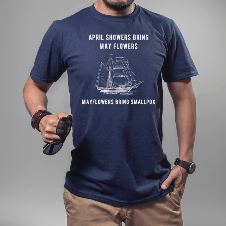 K&ouml;nnte beinhalten: Ein marineblaues T-Shirt mit einer wei&szlig;en Grafik eines Schiffes und dem Text "April showers bring May flowers. Mayflowers bring smallpox."