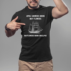 K&ouml;nnte beinhalten: Schwarzes T-Shirt mit wei&szlig;em Text, der "April showers bring May flowers. Mayflowers bring smallpox." lautet, und einer Zeichnung eines Schiffes.