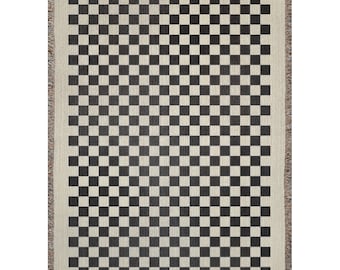 May include: Black and white checkered woven throw blanket with fringe on all sides.
