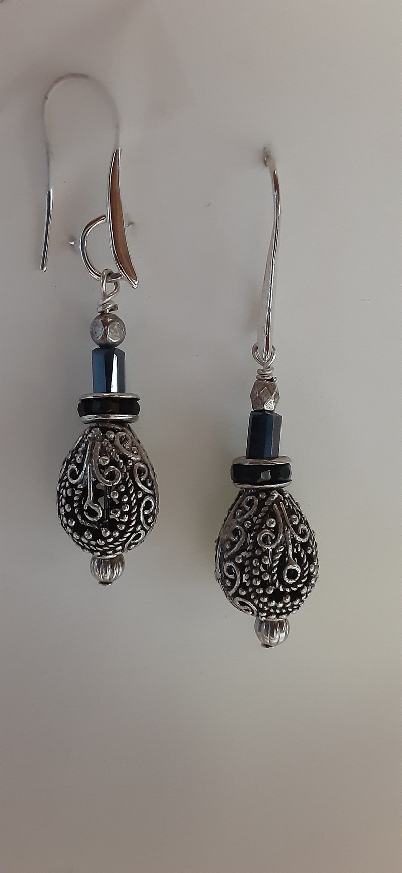Silver tone ornate drop bead with dark blue crystal accents