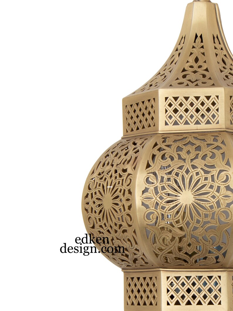 May include: A gold metal lantern with intricate cut-out designs. The lantern has a round body with a pointed top and a hexagonal base.