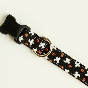 May include: Black dog collar with a Halloween print featuring white ghosts and orange pumpkins.