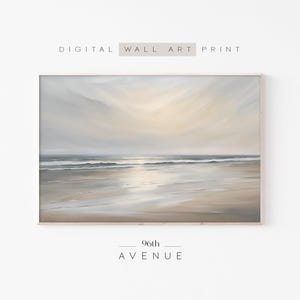 Könnte beinhalten: Ein digitaler Wandkunstdruck mit einem Landschaftsgemälde eines Strandes bei Sonnenuntergang in sanften, gedämpften Beige-, Grau- und Weißtönen. Der Himmel ist mit dunstigen Wolken gefüllt und der nasse Sand reflektiert das Licht. Text: DIGITAL WALL ART PRINT und 96th AVENUE.
